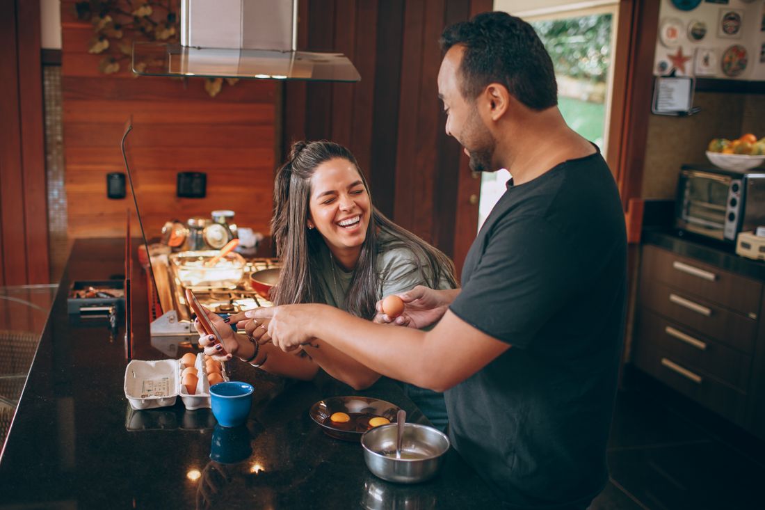 Two adults preparing food together in a kitchen